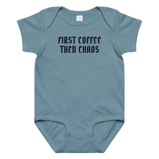 "First Coffee  Then Chaos" printed on a vintage indigo baby jersey bodysuit laying on a flat surface amongst other clothes
