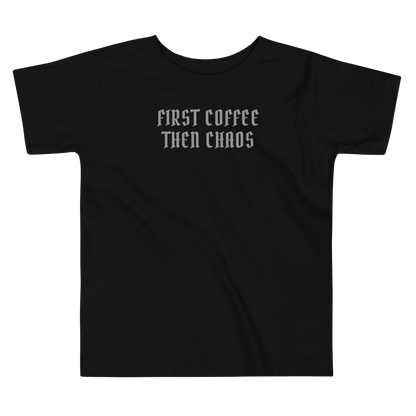 "First Coffee  Then Chaos" printed on a black toddler short sleeve tee laying on a flat surface