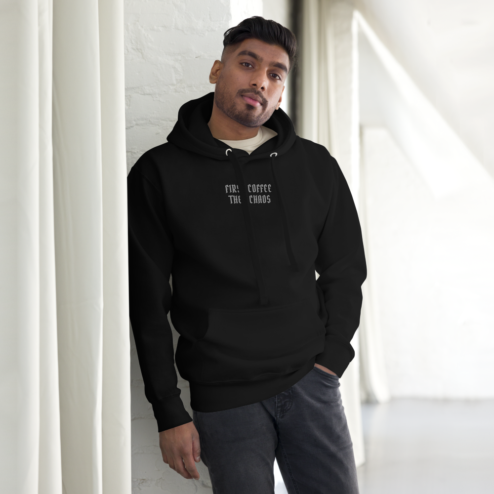"First Coffee  Then Chaos" printed on a black unisex hoodie worn by a male