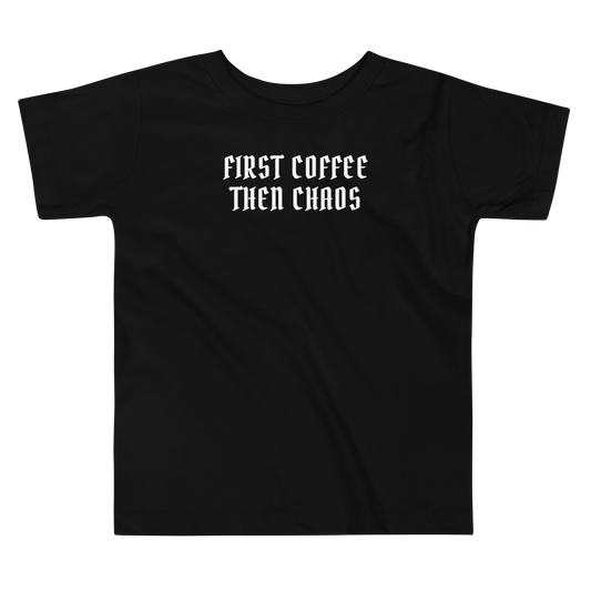 "First Coffee  Then Chaos" printed on a black toddler short sleeve tee laying on a flat surface