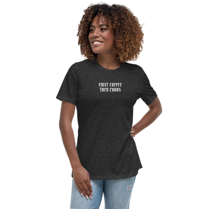"First Coffee  Then Chaos" printed on a dark grey heather women's relaxed t-shirt worn by a female