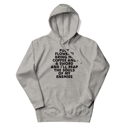 "Fuck Flowers! Bring Me Coffee And A Sword And I'll Reap The Souls Of My Enemies" printed on a carbon grey unisex hoodie laying on a flat surface with the hood up