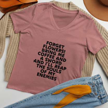 "Forget Flowers! Bring Me Coffee And A Sword And I'll Reap The Souls Of My Enemies" printed on a heather mauve women's relaxed v-neck t-shirt laying on a flat surface amongst other clothes