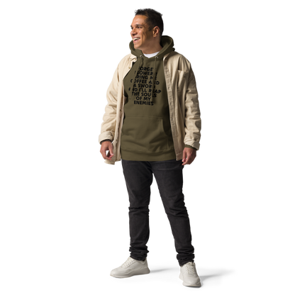"Forget Flowers! Bring Me Coffee And A Sword And I'll Reap The Souls Of My Enemies" printed on a military green unisex hoodie worn by a male with a jacket on top