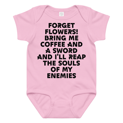 "Forget Flowers! Bring Me Coffee And A Sword And I'll Reap The Souls Of My Enemies" printed on a pink baby jersey bodysuit laying on a flat surface amongst other clothes