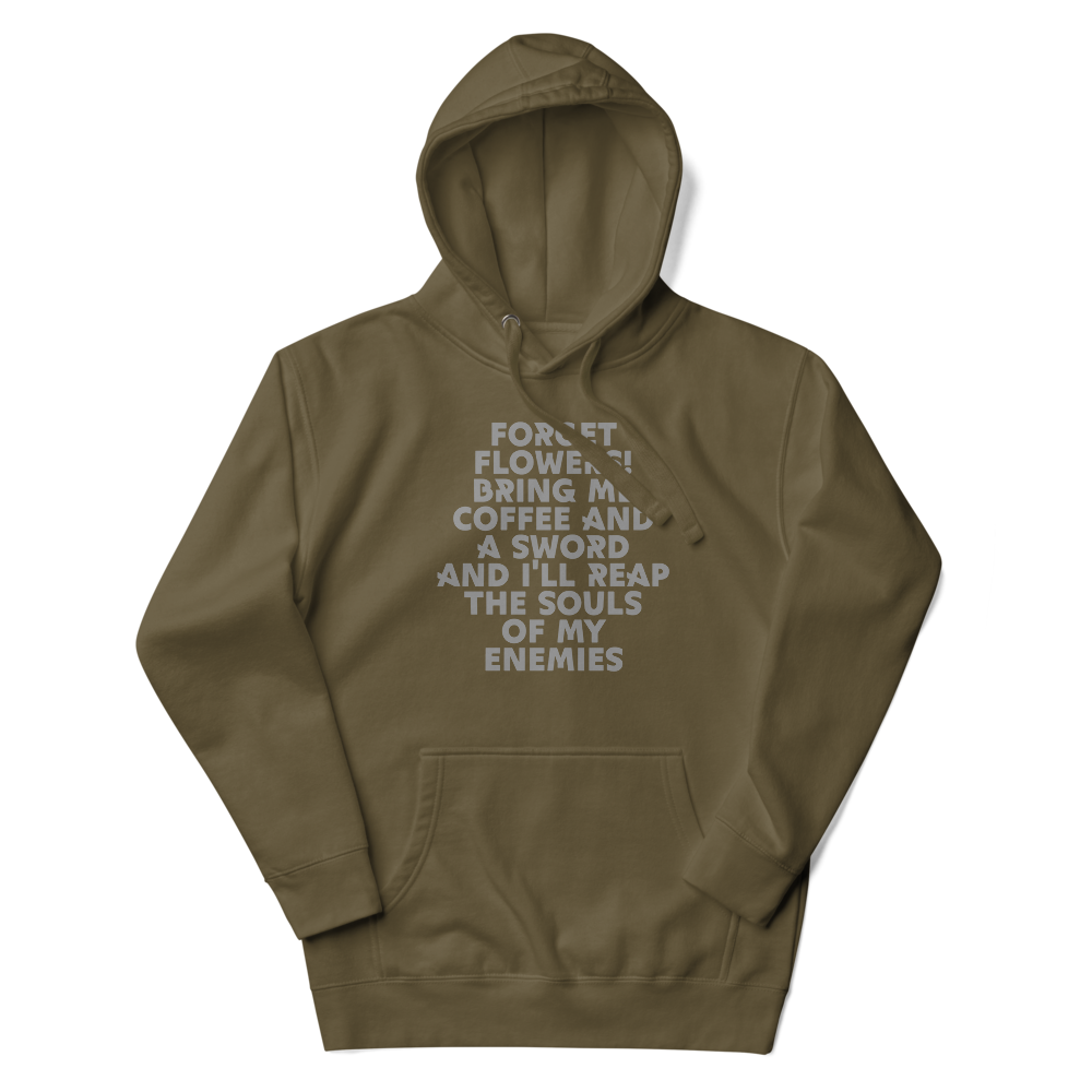 "Forget Flowers! Bring Me Coffee And A Sword And I'll Reap The Souls Of My Enemies" printed on a military green unisex hoodie laying on a flat surface with the hood up