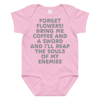 "Forget Flowers! Bring Me Coffee And A Sword And I'll Reap The Souls Of My Enemies" printed on a pink baby jersey bodysuit laying on a flat surface amongst other clothes