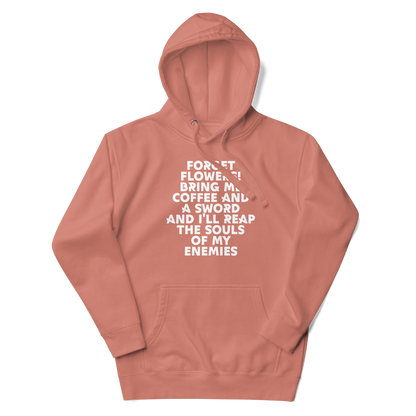 "Forget Flowers! Bring Me Coffee And A Sword And I'll Reap The Souls Of My Enemies" printed on a dusty rose unisex hoodie laying on a flat surface with the hood up