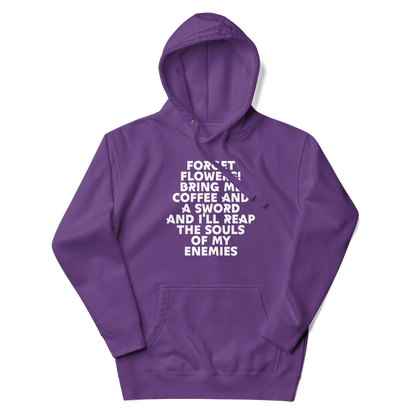 "Forget Flowers! Bring Me Coffee And A Sword And I'll Reap The Souls Of My Enemies" printed on a purple unisex hoodie laying on a flat surface with the hood up