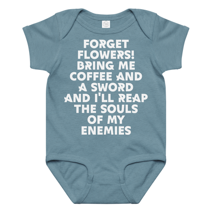 "Forget Flowers! Bring Me Coffee And A Sword And I'll Reap The Souls Of My Enemies" printed on a vintage indigo baby jersey bodysuit laying on a flat surface amongst other clothes