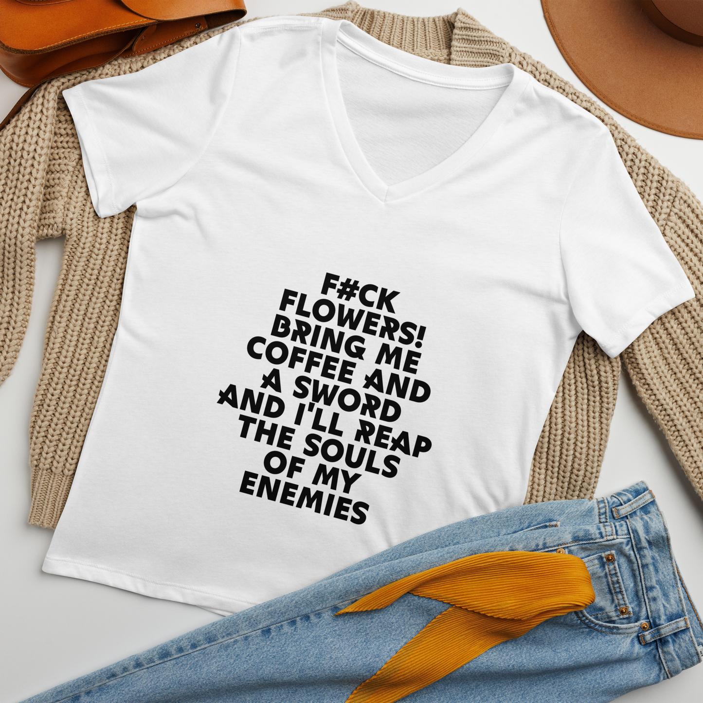 "F#Ck Flowers! Bring Me Coffee And A Sword And I'll Reap The Souls Of My Enemies" printed on a solid white blend women's relaxed v-neck t-shirt laying on a flat surface amongst other clothes