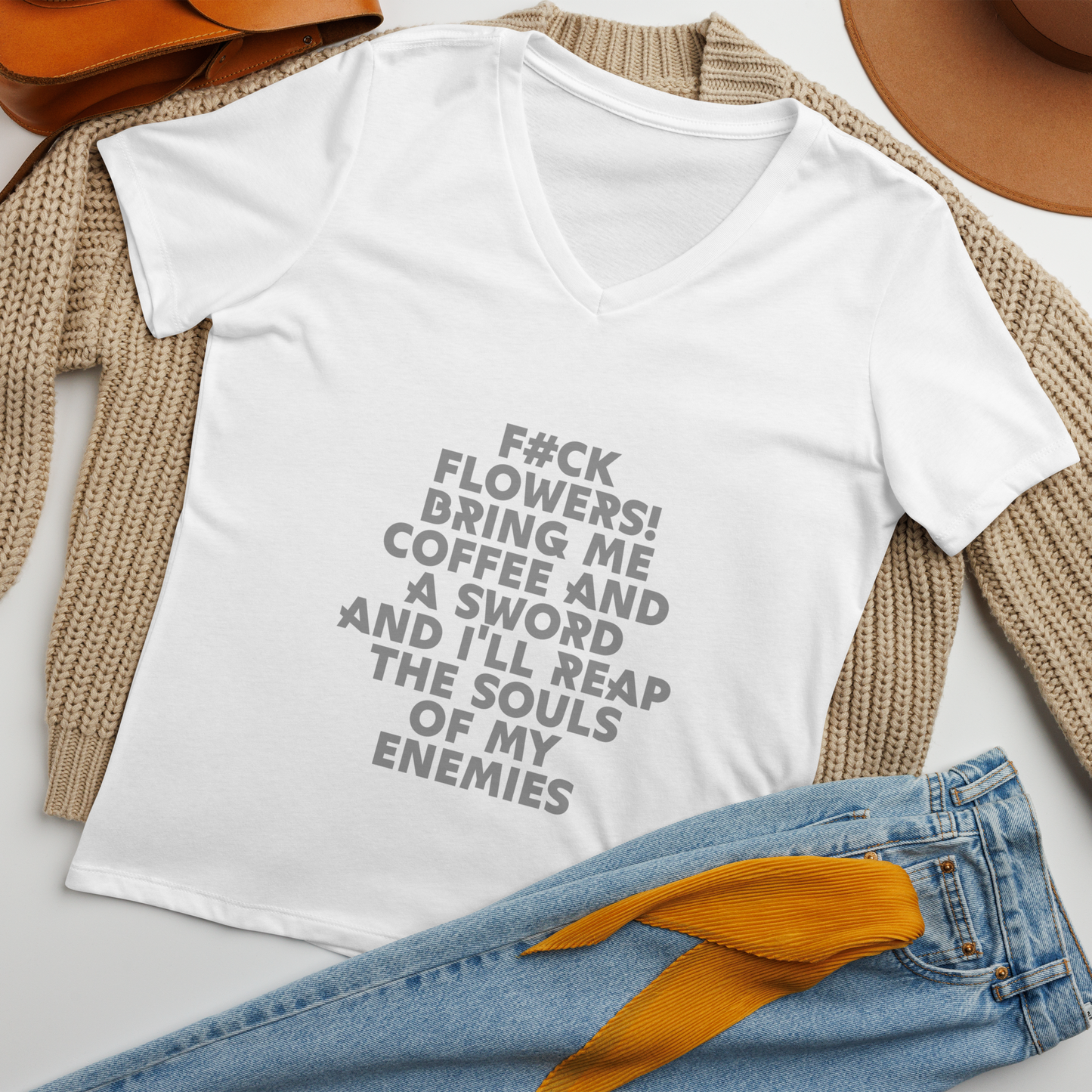 "F#Ck Flowers! Bring Me Coffee And A Sword And I'll Reap The Souls Of My Enemies" printed on a solid white blend women's relaxed v-neck t-shirt laying on a flat surface amongst other clothes