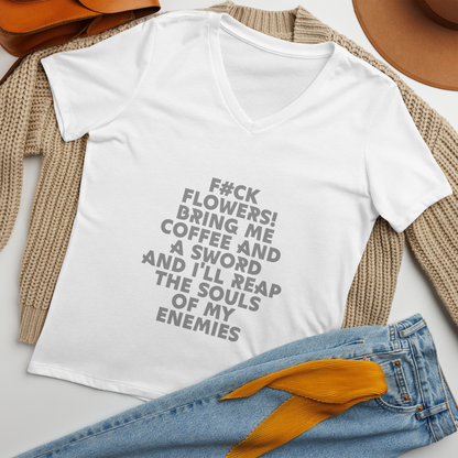 "F#Ck Flowers! Bring Me Coffee And A Sword And I'll Reap The Souls Of My Enemies" printed on a solid white blend women's relaxed v-neck t-shirt laying on a flat surface amongst other clothes