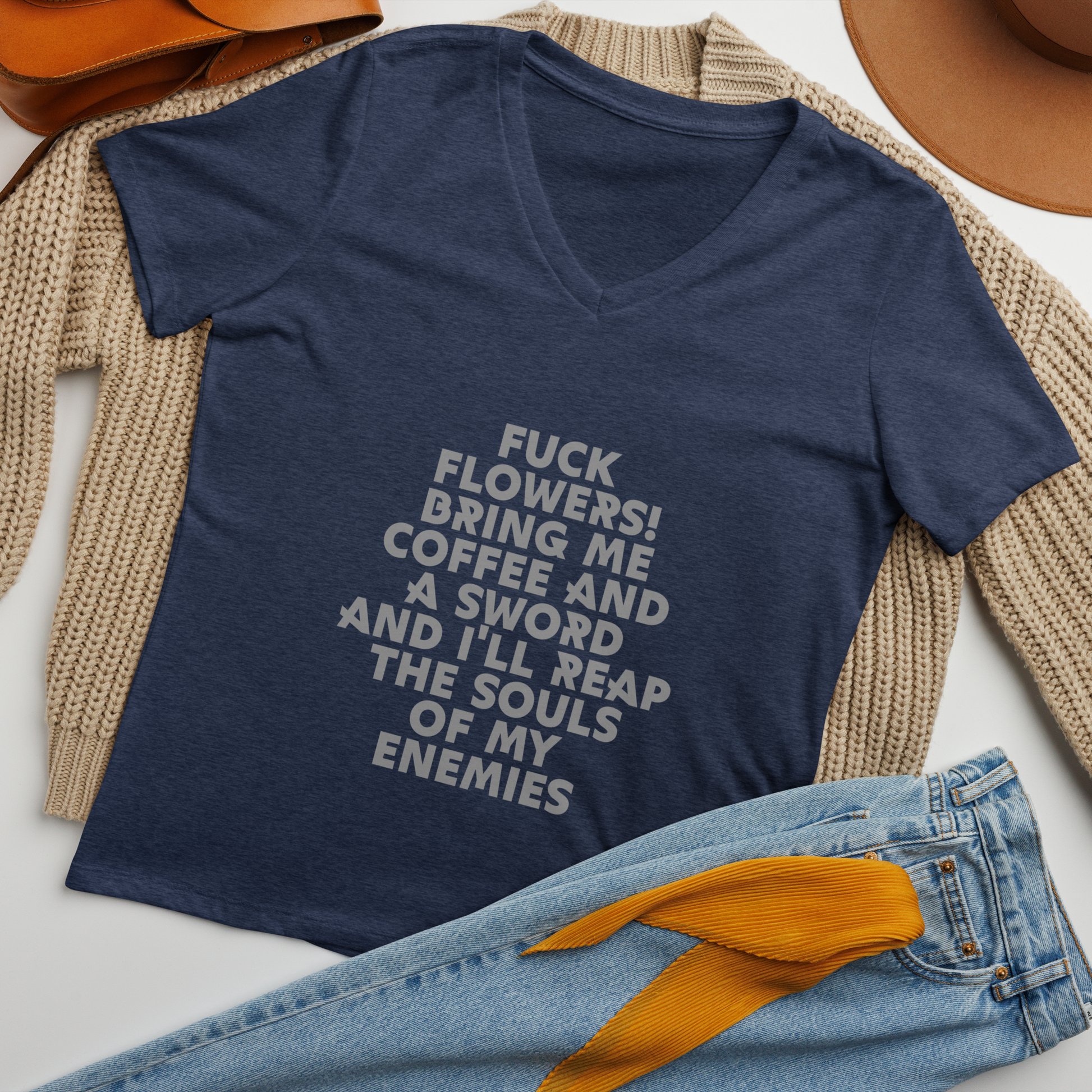 "Fuck Flowers! Bring Me Coffee And A Sword And I'll Reap The Souls Of My Enemies" printed on a heather navy women's relaxed v-neck t-shirt laying on a flat surface amongst other clothes