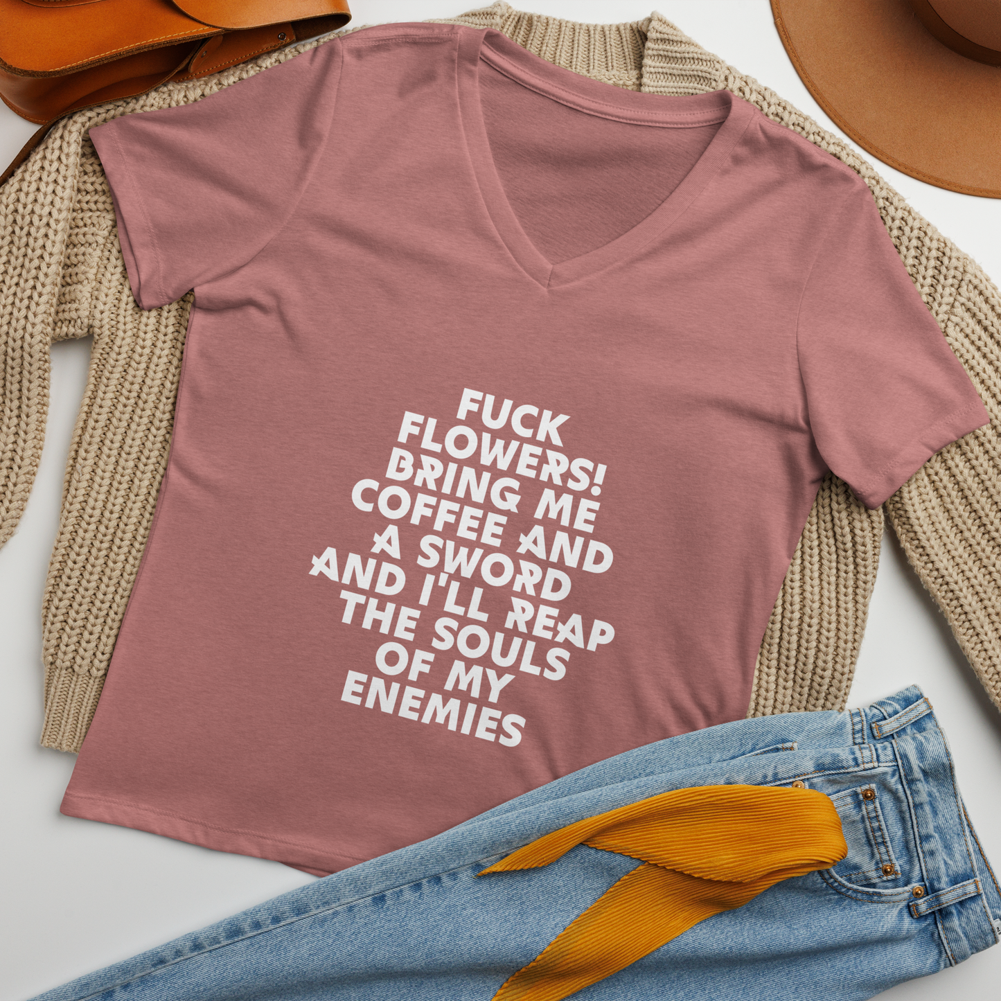 "Fuck Flowers! Bring Me Coffee And A Sword And I'll Reap The Souls Of My Enemies" printed on a heather mauve women's relaxed v-neck t-shirt laying on a flat surface amongst other clothes