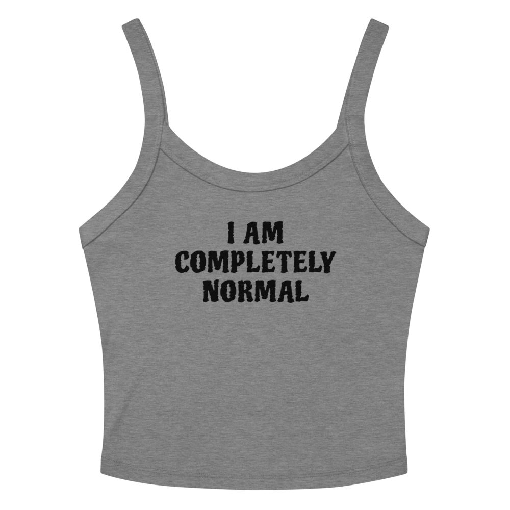 "I am completely normal" printed on a athletic heather women's micro-rib tanktop laying on a flat surface amongst sunglasses and shorts