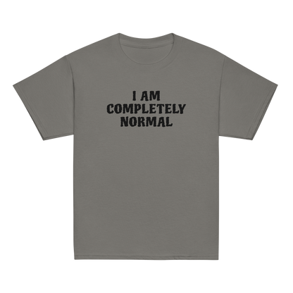 "I am completely normal" printed on a charcoal youth classic tee laying on a flat surface