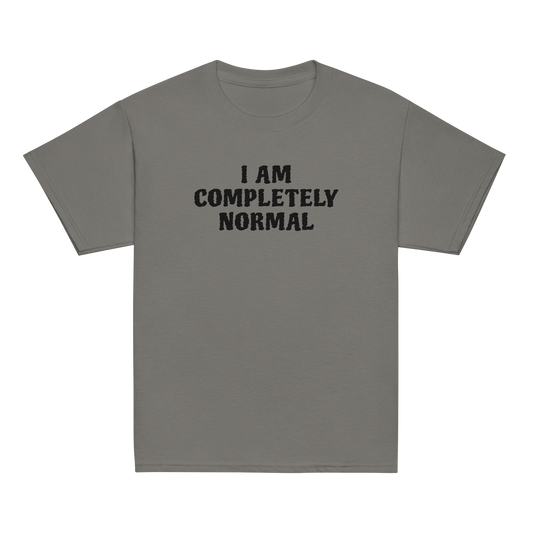 "I am completely normal" printed on a charcoal youth classic tee laying on a flat surface