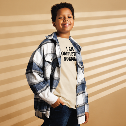 "I am completely normal" printed on a natural youth classic tee worn by a male also wearing a jacket