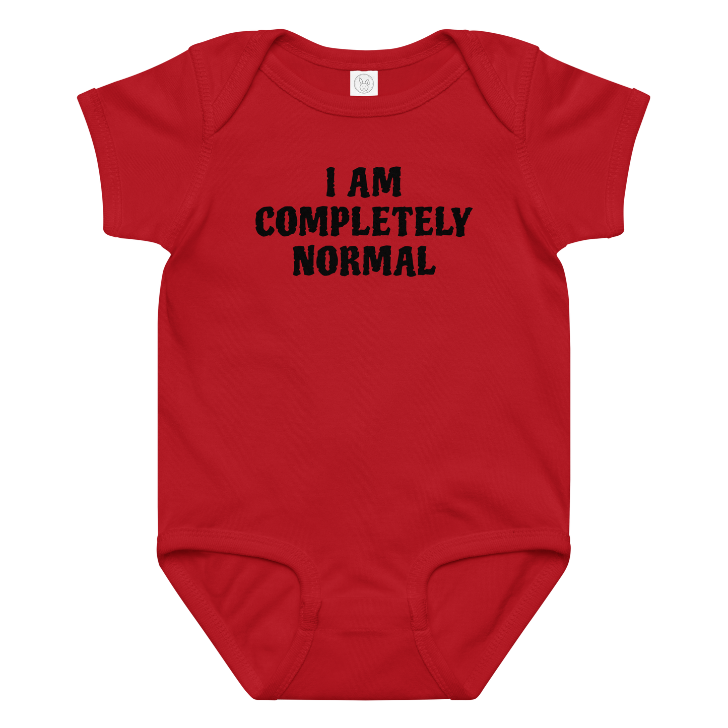"I am completely normal" printed on a red baby jersey bodysuit laying on a flat surface amongst other clothes