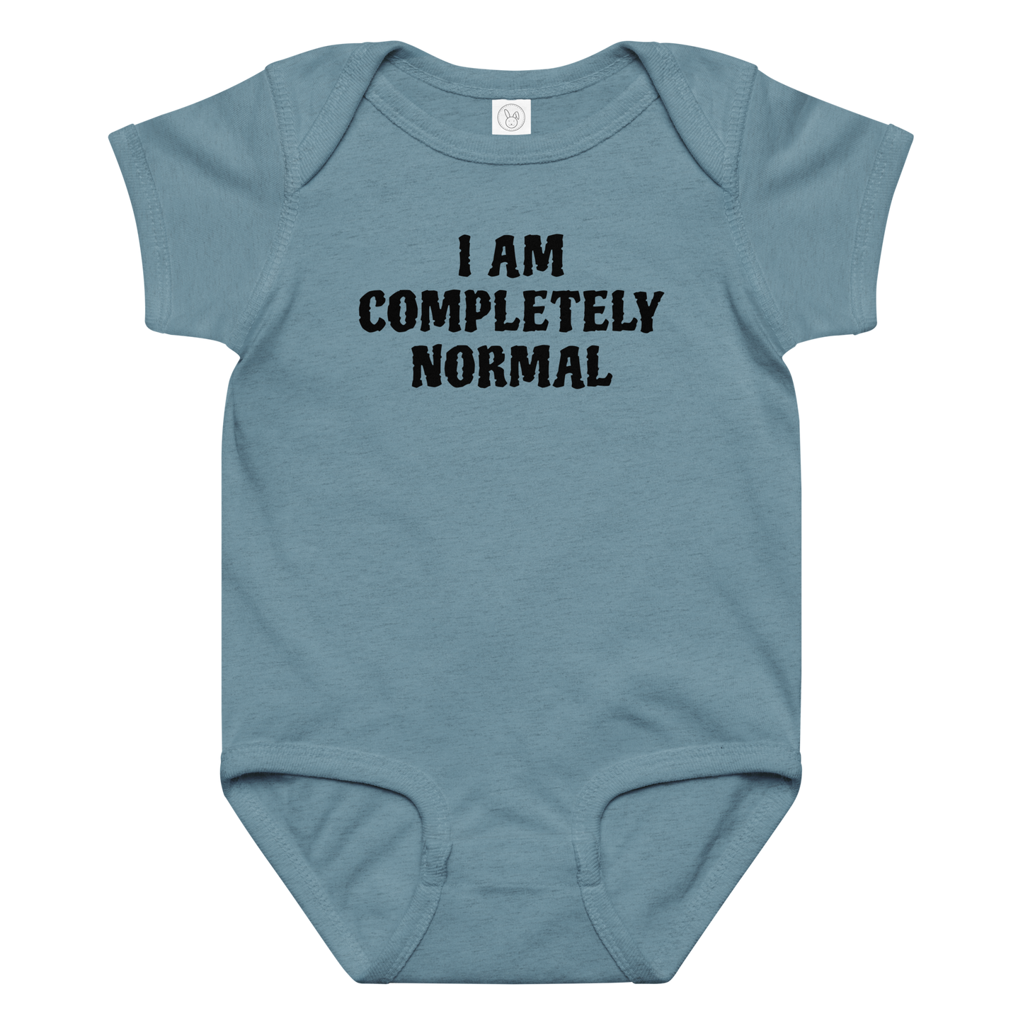 "I am completely normal" printed on a vintage indigo baby jersey bodysuit laying on a flat surface amongst other clothes