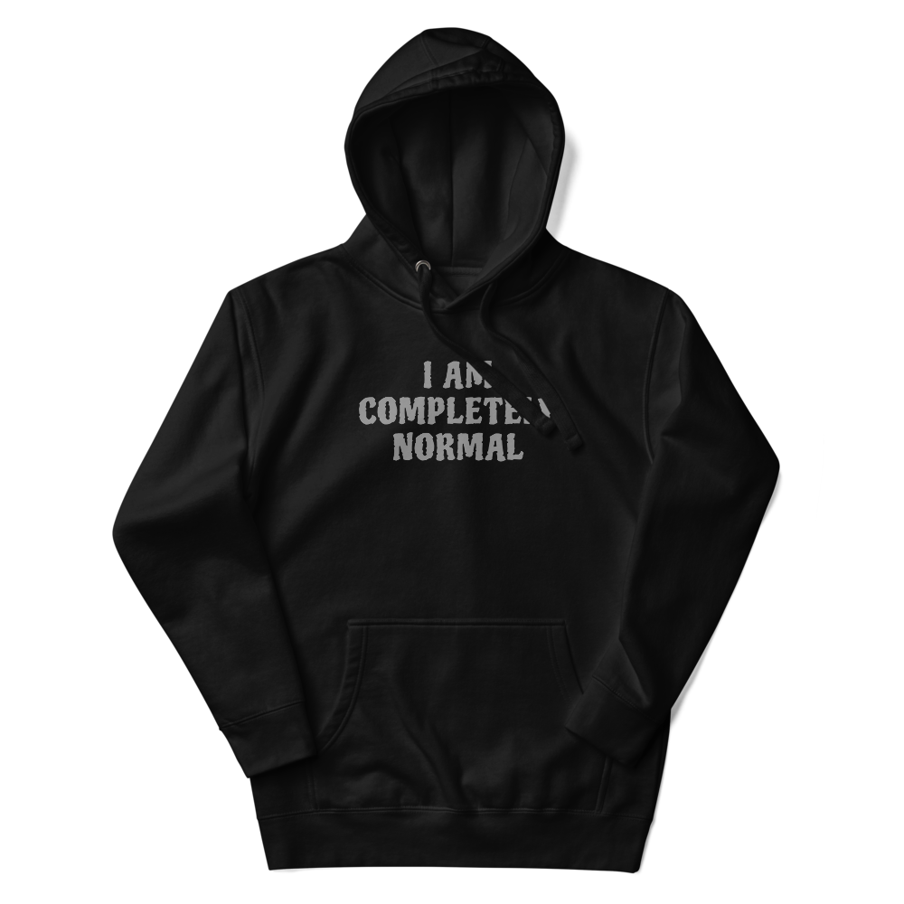 "I am completely normal" printed on a black unisex hoodie laying on a flat surface with the hood up
