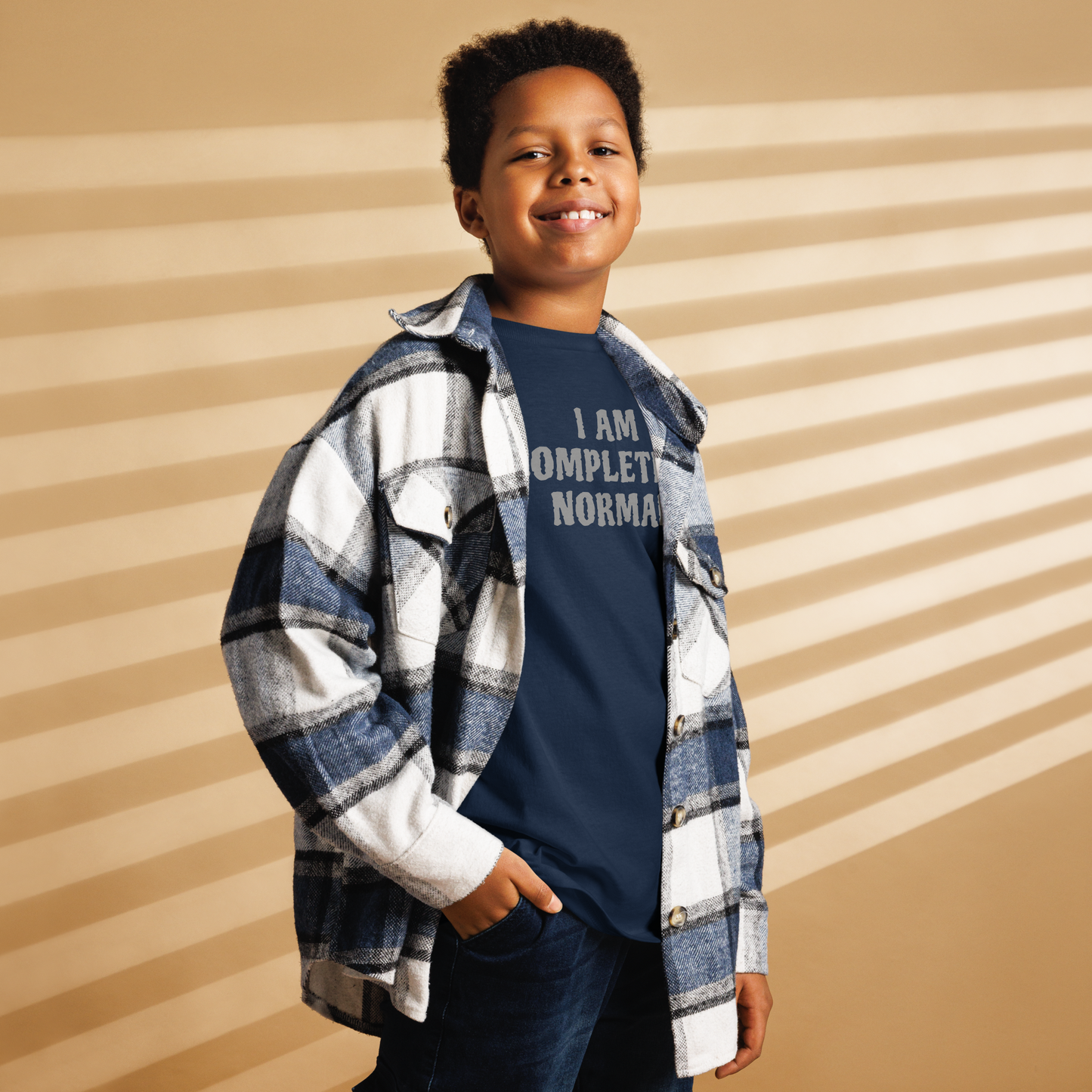 "I am completely normal" printed on a navy youth classic tee worn by a male also wearing a jacket