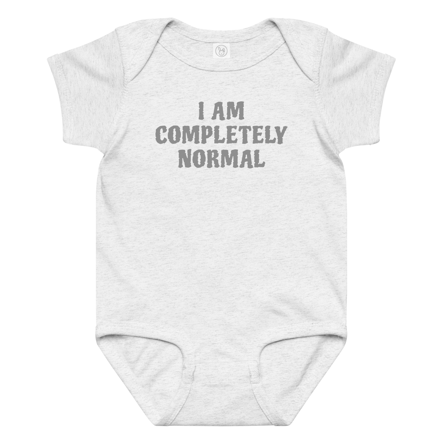 "I am completely normal" printed on a ash baby jersey bodysuit laying on a flat surface amongst other clothes