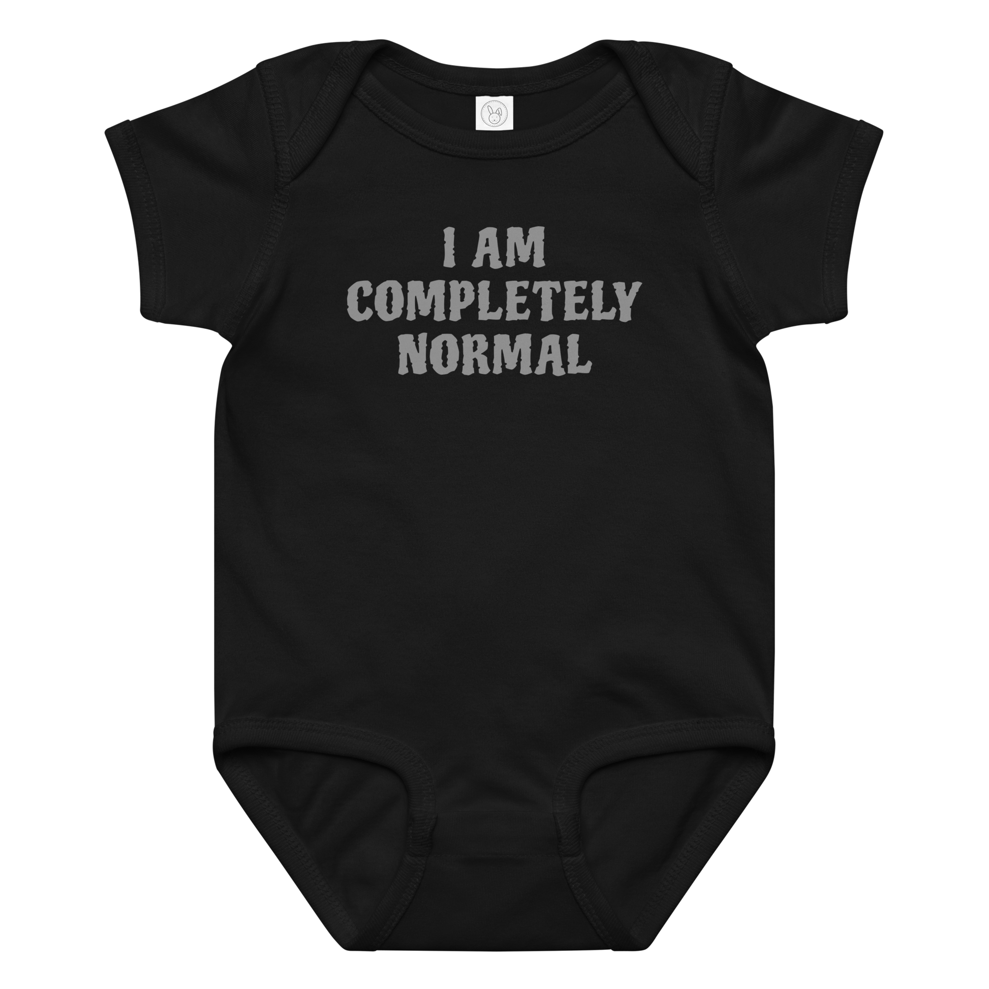 "I am completely normal" printed on a black baby jersey bodysuit laying on a flat surface amongst other clothes