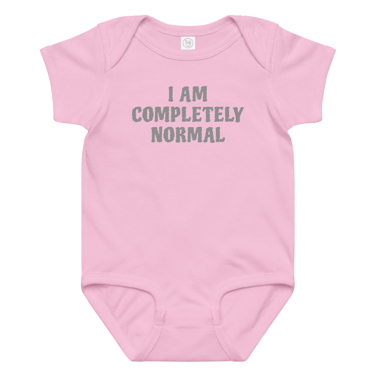 "I am completely normal" printed on a pink baby jersey bodysuit laying on a flat surface amongst other clothes