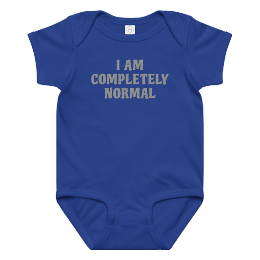 "I am completely normal" printed on a royal baby jersey bodysuit laying on a flat surface amongst other clothes