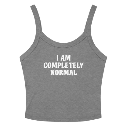 "I am completely normal" printed on a athletic heather women's micro-rib tanktop laying on a flat surface amongst sunglasses and shorts