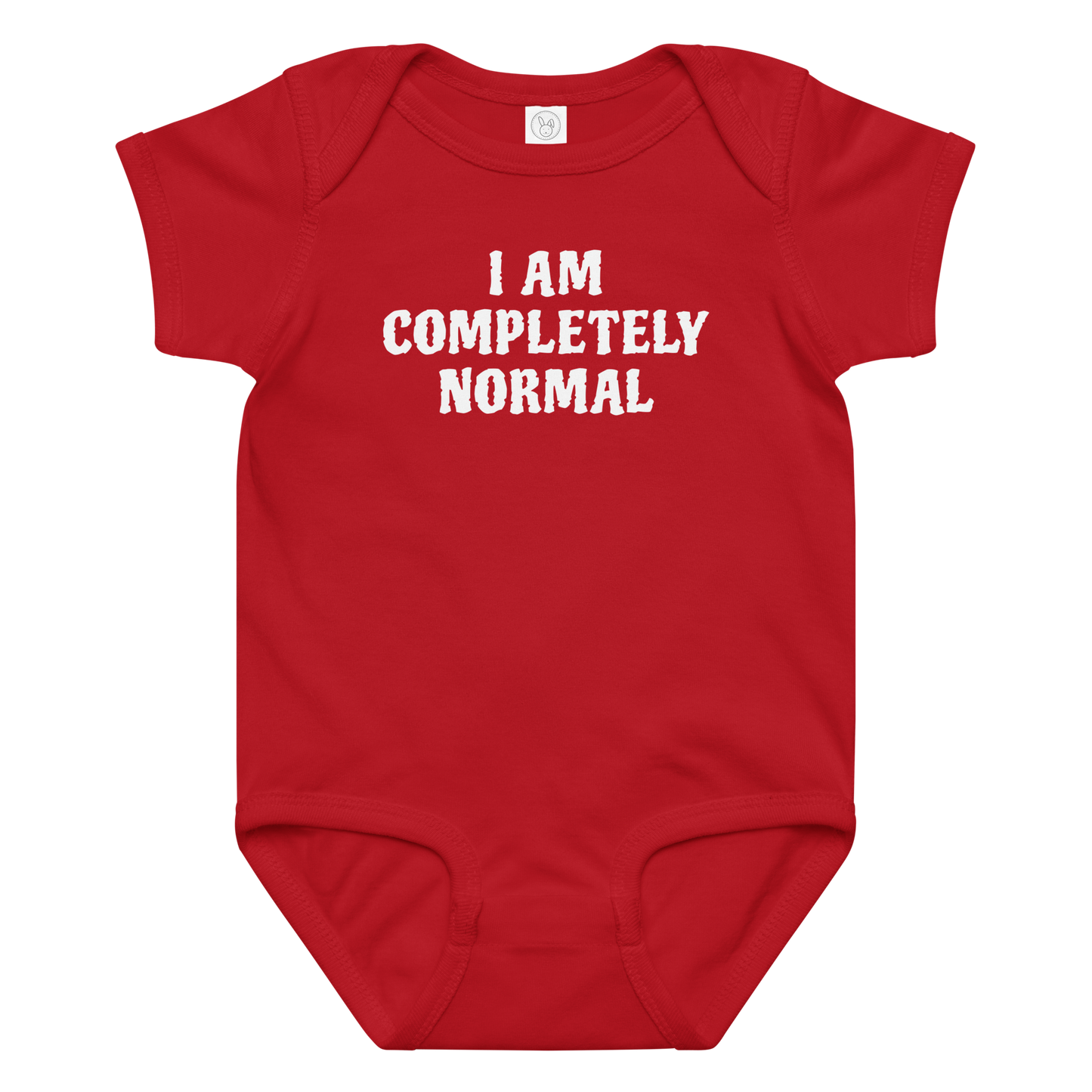 "I am completely normal" printed on a red baby jersey bodysuit laying on a flat surface amongst other clothes