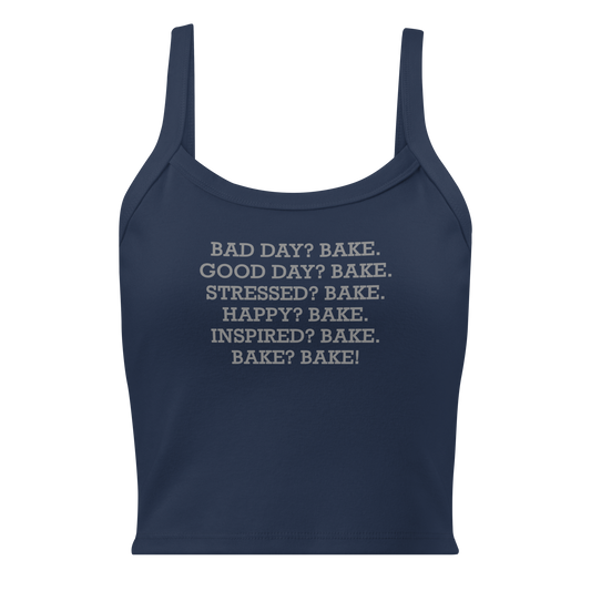 "Bad Day? Bake. Good Day? Bake. Stressed? Bake. Happy? Bake. Inspired? Bake. Bake? Bake!" printed on a solid navy blend women's micro-rib tanktop laying on a flat surface