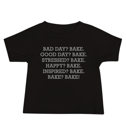 "Bad Day? Bake. Good Day? Bake. Stressed? Bake. Happy? Bake. Inspired? Bake. Bake? Bake!" printed on a black baby jersey short sleeve tee laying on a flat surface