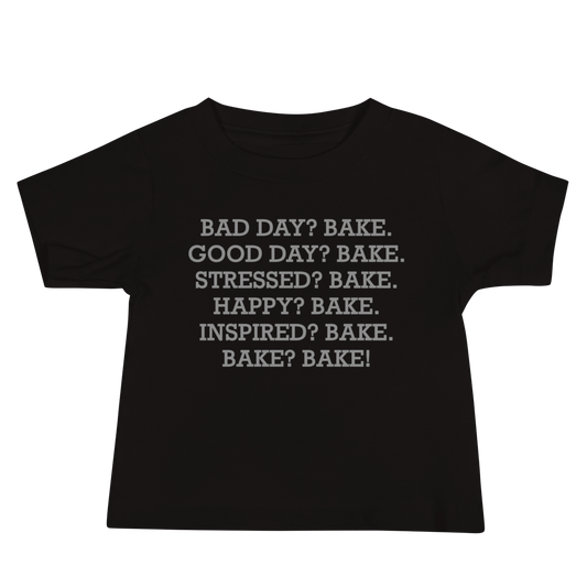 "Bad Day? Bake. Good Day? Bake. Stressed? Bake. Happy? Bake. Inspired? Bake. Bake? Bake!" printed on a black baby jersey short sleeve tee laying on a flat surface