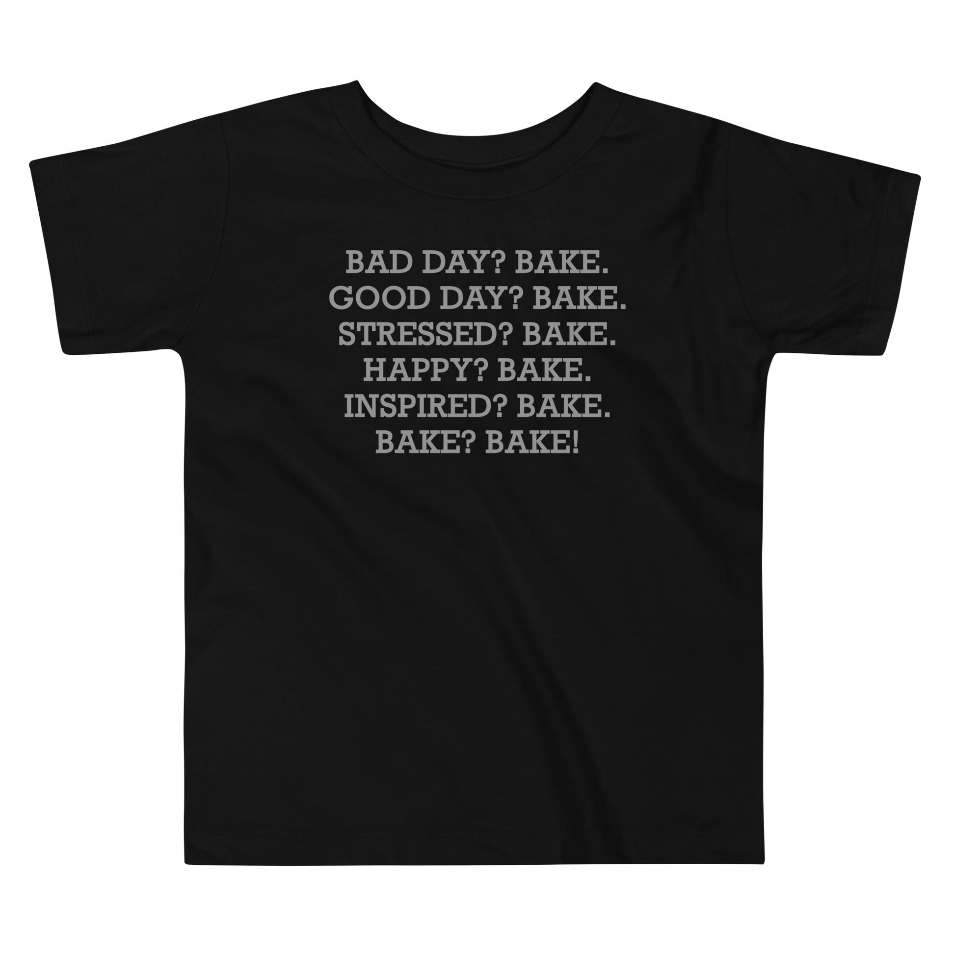 "Bad Day? Bake. Good Day? Bake. Stressed? Bake. Happy? Bake. Inspired? Bake. Bake? Bake!" printed on a black toddler short sleeve tee laying on a flat surface