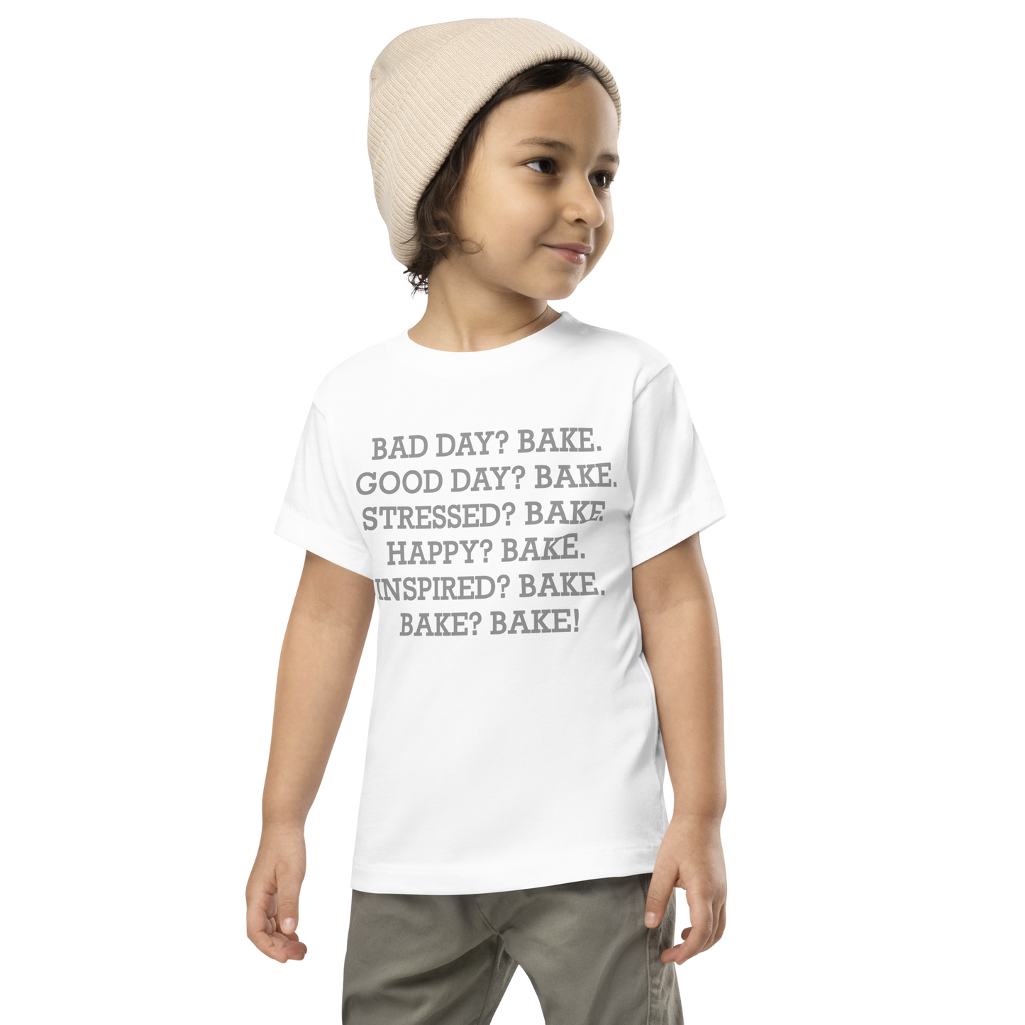 "Bad Day? Bake. Good Day? Bake. Stressed? Bake. Happy? Bake. Inspired? Bake. Bake? Bake!" printed on a white toddler short sleeve tee worn by a male wearing a cap