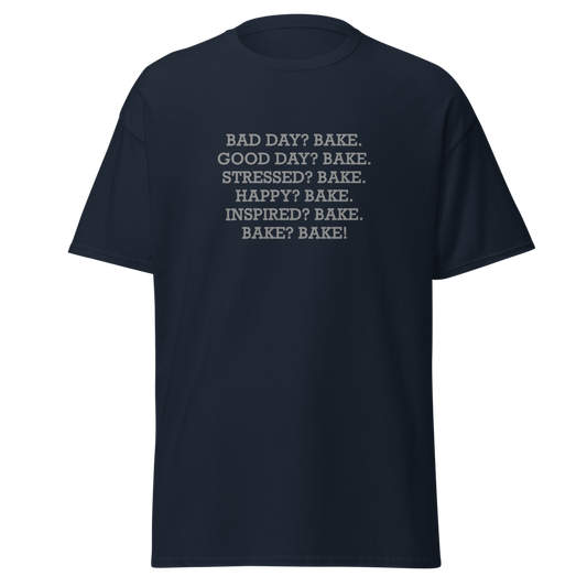 "Bad Day? Bake. Good Day? Bake. Stressed? Bake. Happy? Bake. Inspired? Bake. Bake? Bake!" printed on a navy unisex classic tee laying on a flat surface