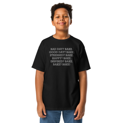 "Bad Day? Bake. Good Day? Bake. Stressed? Bake. Happy? Bake. Inspired? Bake. Bake? Bake!" printed on a black youth classic tee worn by a male