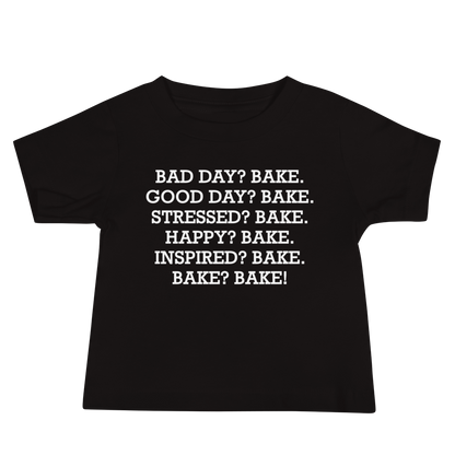 "Bad Day? Bake. Good Day? Bake. Stressed? Bake. Happy? Bake. Inspired? Bake. Bake? Bake!" printed on a black baby jersey short sleeve tee laying on a flat surface