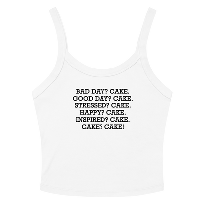 "Bad Day? Cake. Good Day? Cake. Stressed? Cake. Happy? Cake. Inspired? Cake. Cake? Cake!" printed on a solid white blend women's micro-rib tanktop laying on a flat surface amongst sunglasses and shorts
