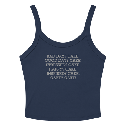 "Bad Day? Cake. Good Day? Cake. Stressed? Cake. Happy? Cake. Inspired? Cake. Cake? Cake!" printed on a solid navy blend women's micro-rib tanktop laying on a flat surface amongst sunglasses and shorts