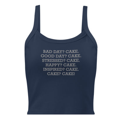 "Bad Day? Cake. Good Day? Cake. Stressed? Cake. Happy? Cake. Inspired? Cake. Cake? Cake!" printed on a solid navy blend women's micro-rib tanktop laying on a flat surface