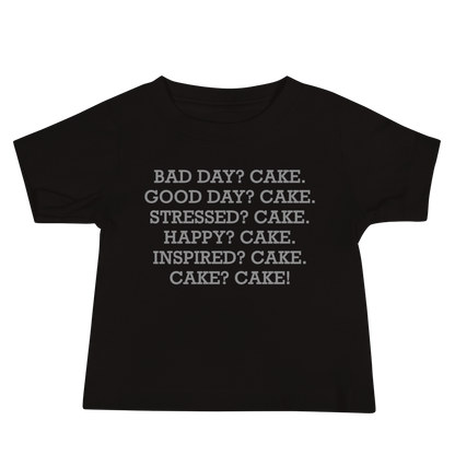 "Bad Day? Cake. Good Day? Cake. Stressed? Cake. Happy? Cake. Inspired? Cake. Cake? Cake!" printed on a black baby jersey short sleeve tee laying on a flat surface
