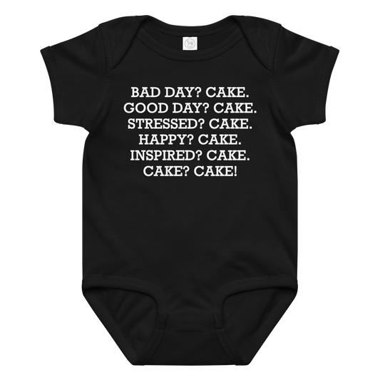 "Bad Day? Cake. Good Day? Cake. Stressed? Cake. Happy? Cake. Inspired? Cake. Cake? Cake!" printed on a black baby jersey bodysuit laying on a flat surface amongst other clothes
