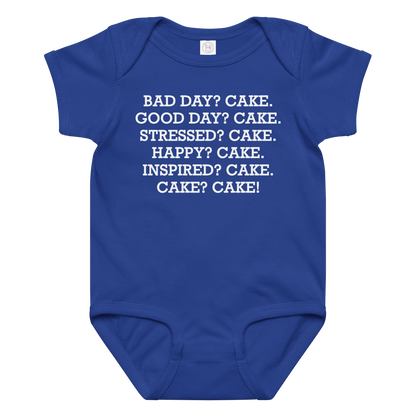 "Bad Day? Cake. Good Day? Cake. Stressed? Cake. Happy? Cake. Inspired? Cake. Cake? Cake!" printed on a royal baby jersey bodysuit laying on a flat surface amongst other clothes