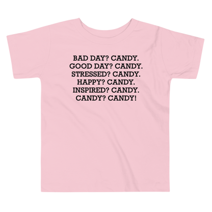"Bad Day? Candy. Good Day? Candy. Stressed? Candy. Happy? Candy. Inspired? Candy. Candy? Candy!" printed on a pink toddler short sleeve tee laying on a flat surface