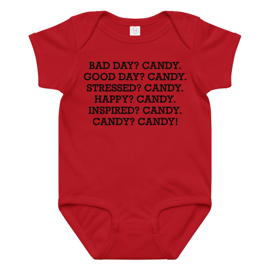 "Bad Day? Candy. Good Day? Candy. Stressed? Candy. Happy? Candy. Inspired? Candy. Candy? Candy!" printed on a red baby jersey bodysuit laying on a flat surface amongst other clothes