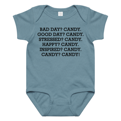 "Bad Day? Candy. Good Day? Candy. Stressed? Candy. Happy? Candy. Inspired? Candy. Candy? Candy!" printed on a vintage indigo baby jersey bodysuit laying on a flat surface amongst other clothes